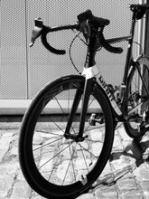 Load image into Gallery viewer, Side profile of a high end black road bike with Bici Shields attached to each of its brake levers. This new bike gadget is designed to keep hands warm while cycling in the cold.
