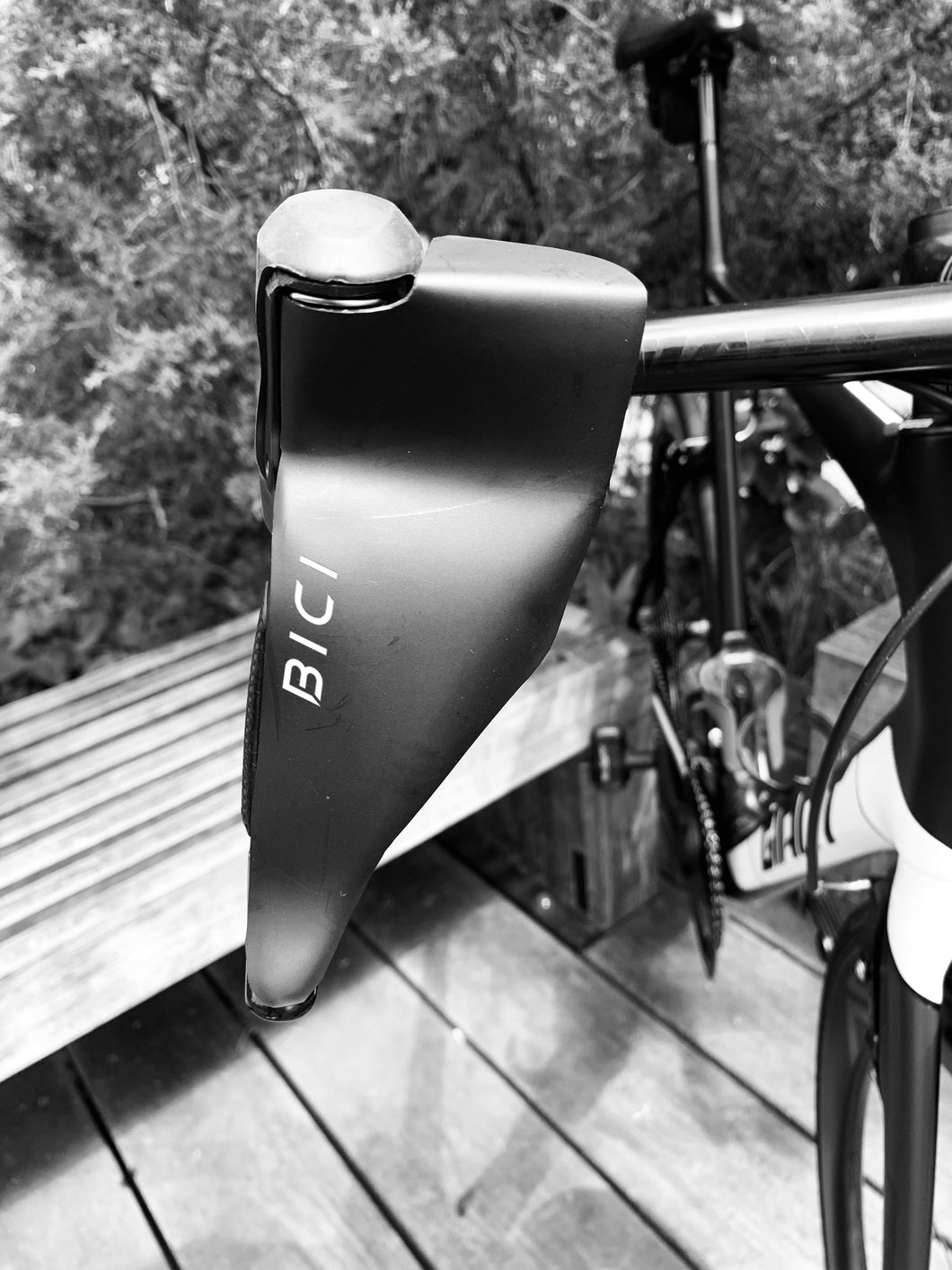 Close up of road bike handlebars with the newest must have winter cycling accessory, The Bici Shield, attached to its brake lever. This streamlined black abs hand protector shields a riders hands from the cold while cycling in the winter.